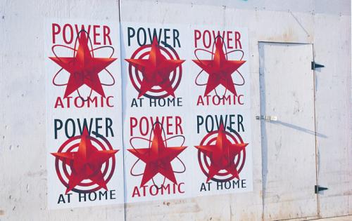 a series of ads that mix communist iconography and images of hydro electricity. 6 posters on wall each say power on top. 3 say at home on the bottom. 3 say atomic at the bottom. With red stars in the center. 