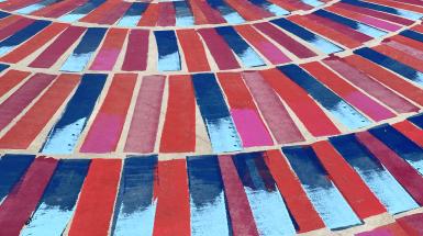 Colourful image of red and blue paint on a concrete surface. 