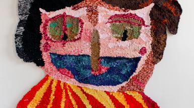 An image of the woven tapestry Pario - a quirky multicoloured clown with a big smile
