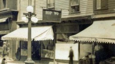 Sepia tinted black and white photo storefront of Hop Wo Laundry