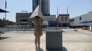 A person contemplating the sounds coming from inside the pyramid, standing in the Sun. 