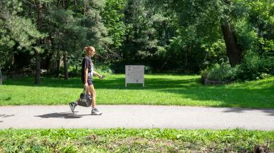 Far away perspective of the billboard with a person walking by.