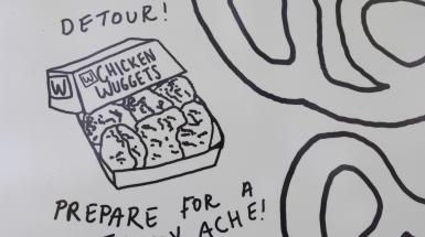 Closeup of an image of chicken nuggets in a box from a fast food company. Text around the image says "Detour!" and "Prepare for a tummy ache!"