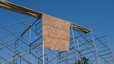 Curtain of clay beads hung on scaffolding.