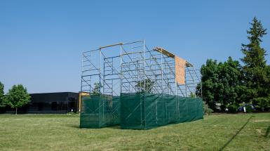 Curtain of clay beads hung on scaffolding.