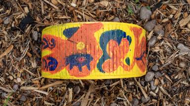 A top-down view of a yellow, orange, and black pattern on a semicircular box that might resemble bugs or flowers.