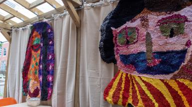 Closer view of two woven faces hung outdoors at the Yeti Cafe.
