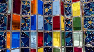 Closeup of many colours of plexiglass panels, all held by an aluminum frame. and yellows next to many colours of plexiglass panels.