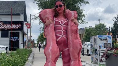 The artist is walking down the street in costume.