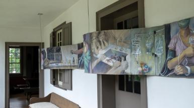 Long, undulating painting of many overlapping scenes.