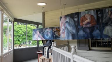 Long, undulating painting of many overlapping scenes.