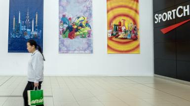 Three of the four vinyl banners with a person walking by them.