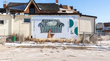 poster of hand holding cross stitched couch shaped tissue box cover. And text that reads big depression, small pleasure.  