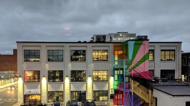 Building with colourful geometric mural on the fire escape stairs. 