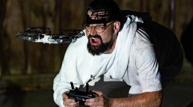 Artist flying small drone, crouched on the ground