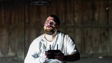 Artist flying small drone above head. 