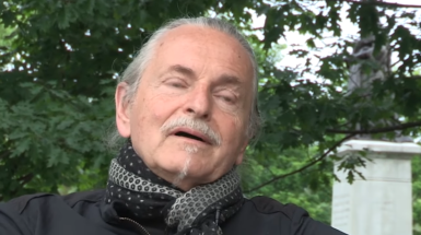 image of artist Kryzysztof Wodiczko talking about his work. 