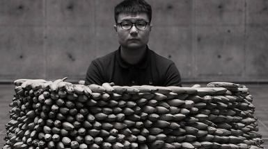 Man sitting in a circle well made of bananas.