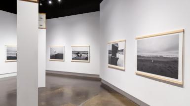 Picture of gallery with four photographs hanging that range in subject matter.