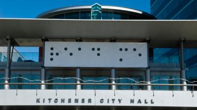 Banner on Kitchener city hall which feature braille with tactile element removed.