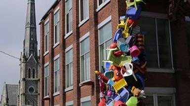 Building with a variety of plastic colourful objects crawling up the corner of it. 