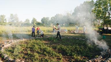 A circle made of stone clay with stick burning within the border. 