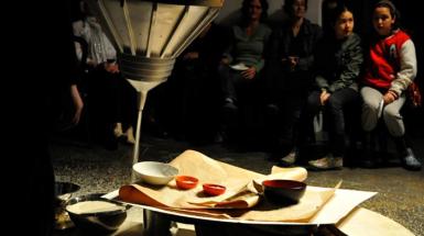 A sheet of paper on top of drums in which multiple different sized bowls sit. 