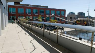 A railing which is wavy and has wooden tool handles protruding from it. 