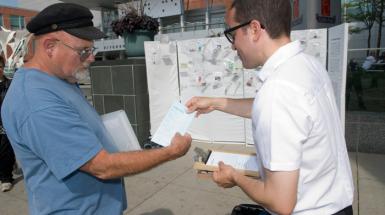 A man handing another man a paper