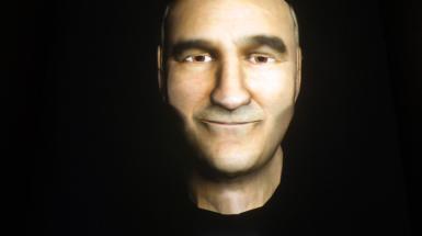 a head with Cartoon mans face projected on with text "what is art"