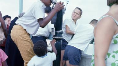 Boy looking though coin to pay binoculars 