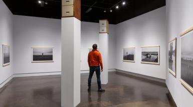 Man in red jacket looking up at filing cabinet of tall plinth