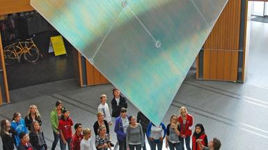 Group of students looking up at large holographic sheet 