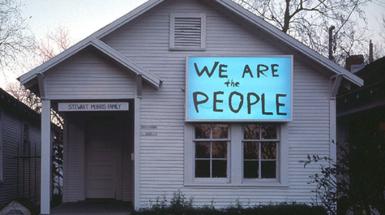House with lit up sign that says we are the people