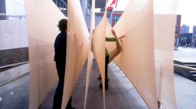 two individuals interacting with sculpture  