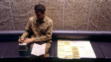 Person sitting with map in lap writing notes
