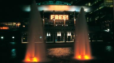 Fountains framing a lit up sign that says free