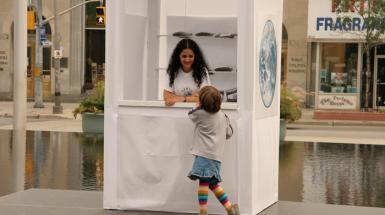 Woman in booth talking to child