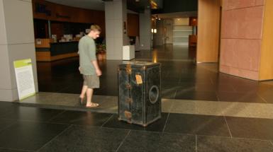 Man looking at black chest suit case