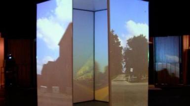 Man made room with on outside and inside walls a projection of a farm. 