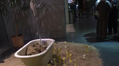 a bathtub, containing a stand with IV bags. A large number of candles, modeled into the form of bones will be assembled around the tub. 