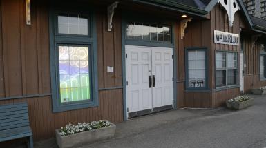 Image of building with window that has neon lights behind it 