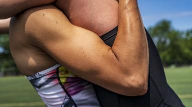 A closeup shot of two bodies pressed together, placing a flexing arm centrally in the frame