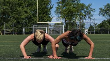 Two women doing push-ups side-by-side