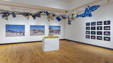 images on walls and art installation hanging from ceiling, above head.