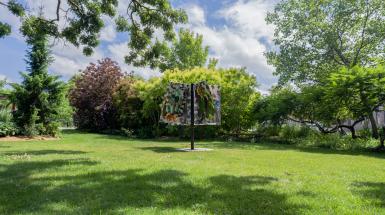 A black pole holds five banners depicting ink drawings of imagined characters