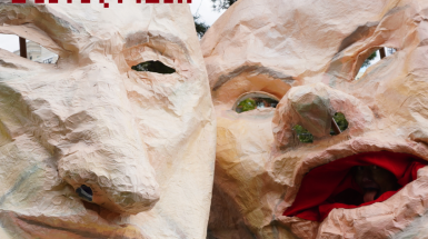 Two giant masks - one of Elon Musk and another of Mark Zuckerberg accompanied by bright yellow-green text saying: MONSTER PAGEANT PARADE. 1-2pm, October 19th.