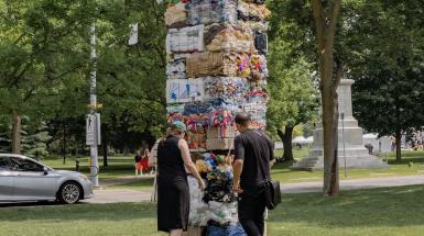 Two people standing on front of two sides of the rectangular monument.