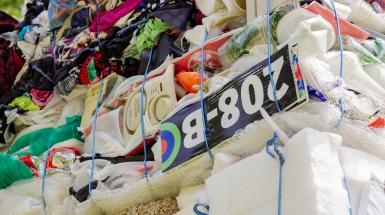 Close up of bales of compacted material – foam, clothing, and signs.