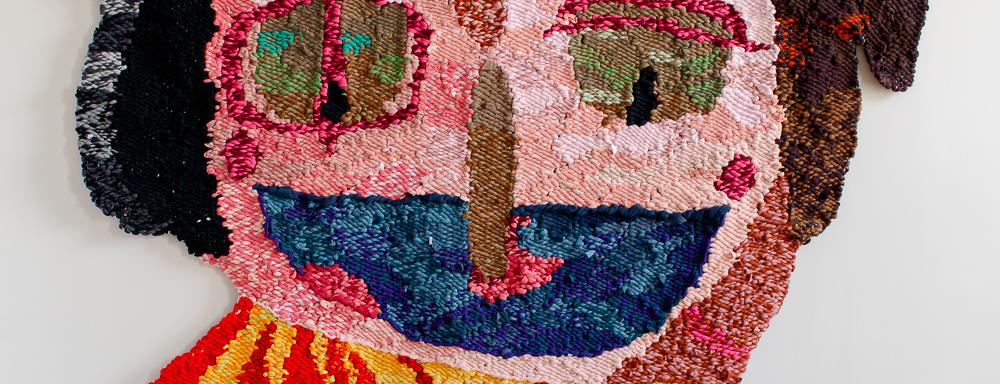 An image of the woven tapestry Pario - a quirky multicoloured clown with a big smile